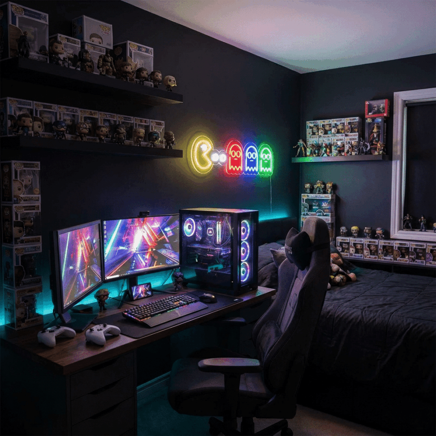 A gaming setup features dual monitors, an RGB-lit PC, a gaming chair, shelves of collectibles, and a cozy atmosphere. Above the desk, Pac-Man Neon lights add vibrant style to the dimly lit room.