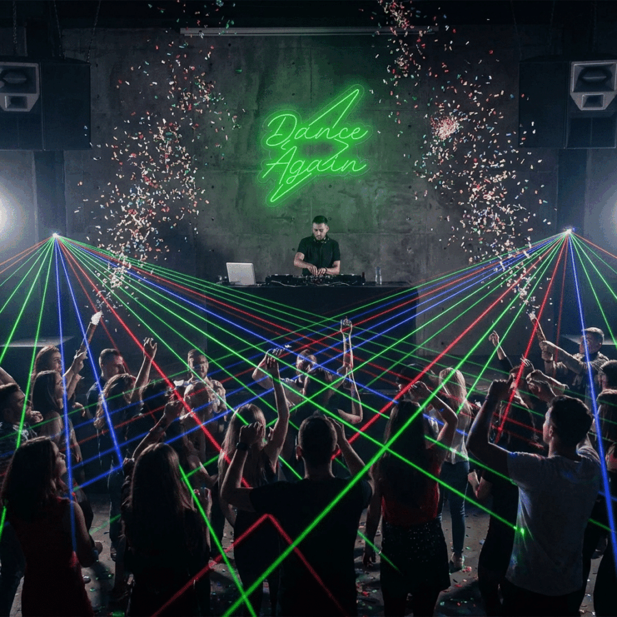 A DJ performs on stage with the Neon Dance Again sign, laser lights, confetti, and a lively crowd—capture the energy at the Neon Take a Selfie spot in this electrifying nightclub scene.