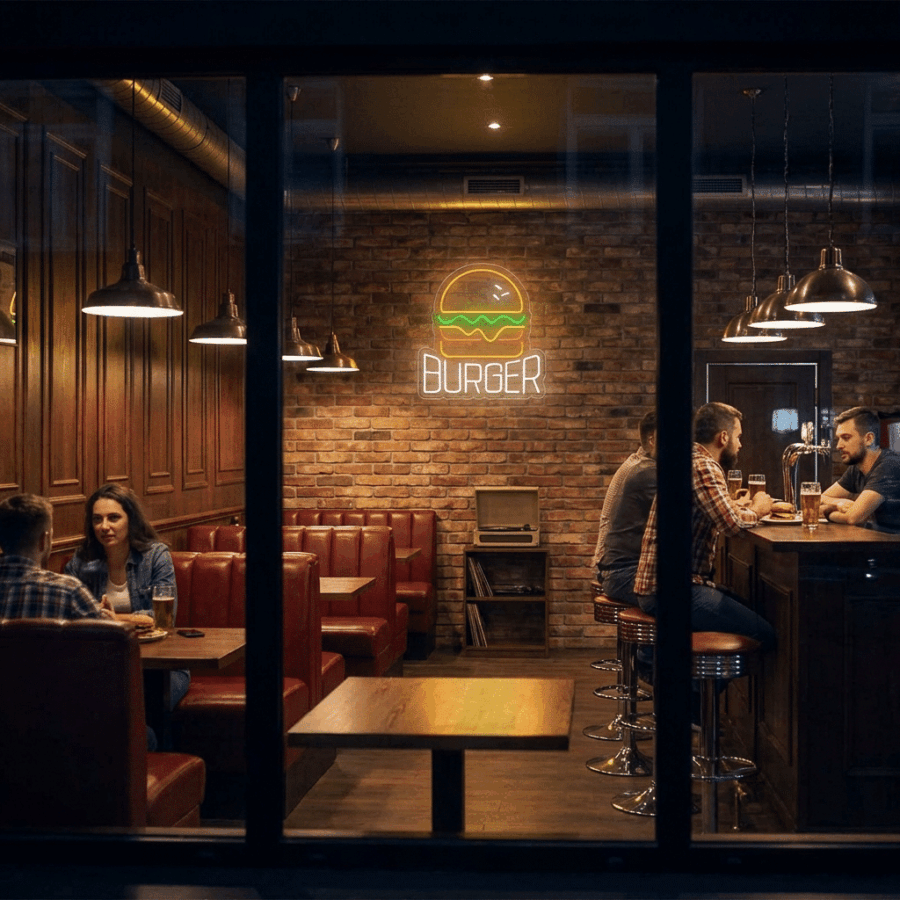 Customers sit at red booths and a bar inside a dimly lit restaurant, surrounded by brick walls and the warm glow of the Neon Burger Sign.