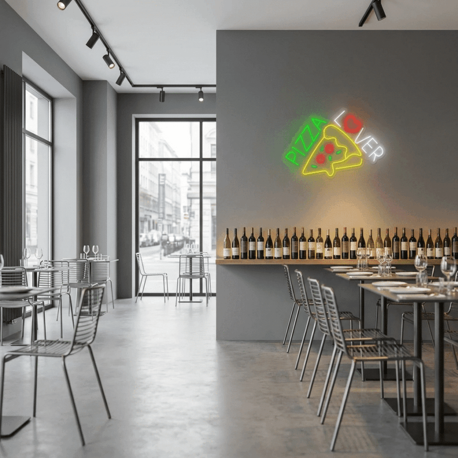 Modern pizzeria interior featuring the Neon Pizza Lover sign with a glowing pizza slice illustration, metal chairs, dining tables, and a long wine bottle shelf.