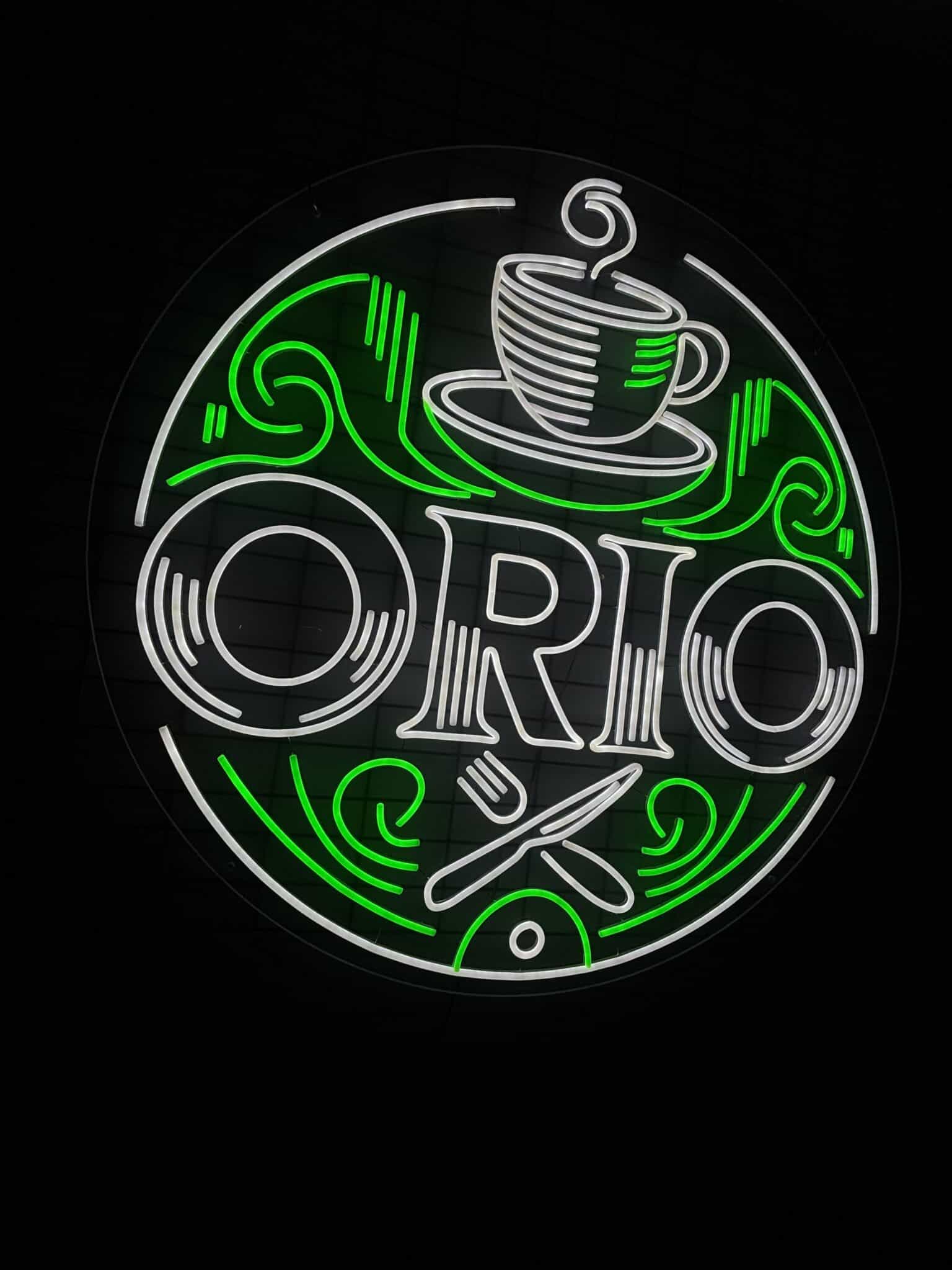 Logotype néon LED blanc froid et vert d’Orio installé dans un local