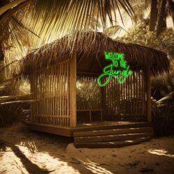 A wooden hut surrounded by tropical plants and palm trees features the Welcome To The Jungle Neon Sign in bright green on the front.